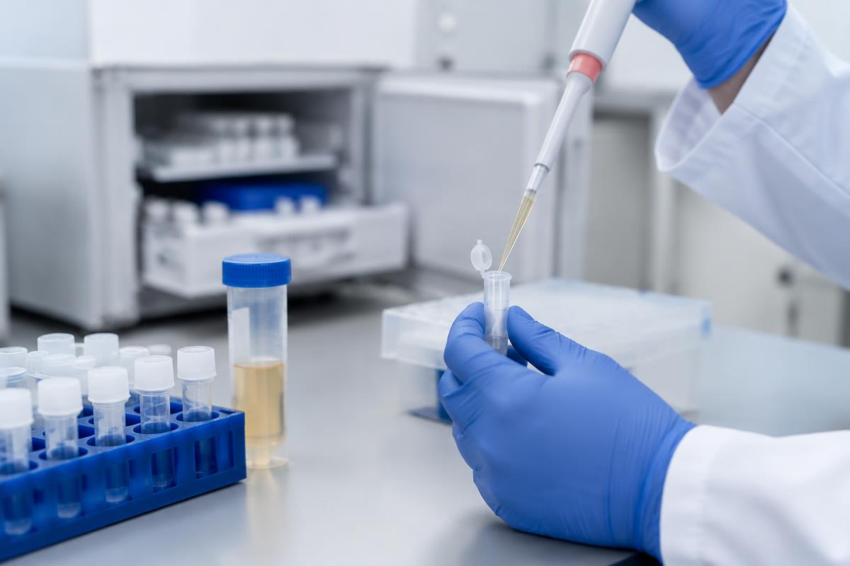Trasegado de suero con pipeta a un vial criogénico frente a un congelador
